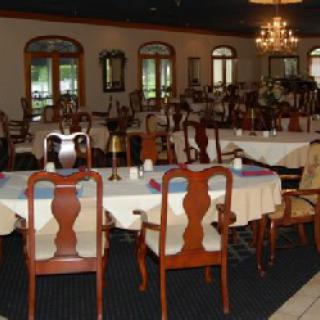 An elegant restaurant dining room with tables and chairs set up for guests.