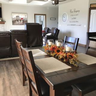 A cozy dining room with a decorated table, featuring flowers and candles for a warm ambiance.