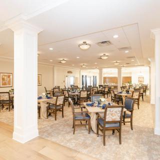 A spacious and well-lit dining area with neatly arranged tables and chairs.