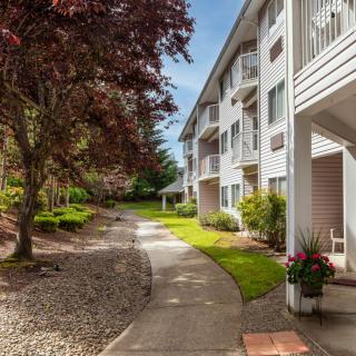 A scenic view of an apartment building with a landscaped garden and pathway.