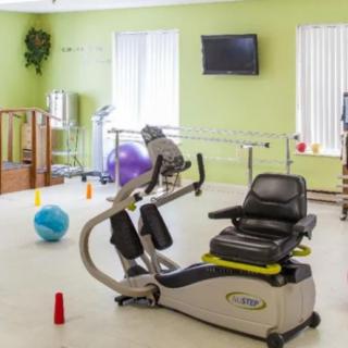 A rehabilitation room equipped with exercise machines and therapy tools.