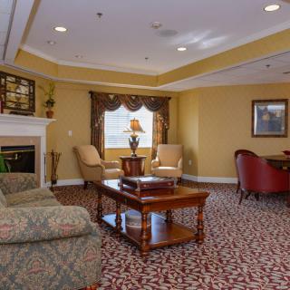 A cozy living room with a fireplace, comfortable seating, and elegant decor.
