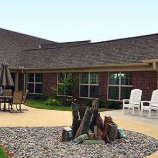 A patio area with chairs and stone landscaping outside a building.