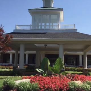 A scenic view of a building with a beautifully landscaped garden in the foreground.
