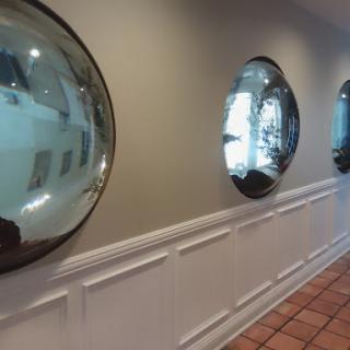A hallway featuring round mirrors that add a modern touch to the interior design.