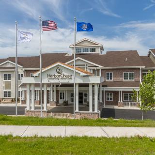 A hotel building with multiple flags at the entrance.