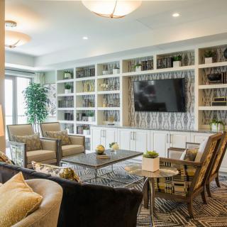 A modern living room with built-in bookshelves, a large TV, and comfortable seating.