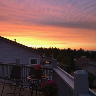 A beautiful sunset view from a deck overlooking a residential area.