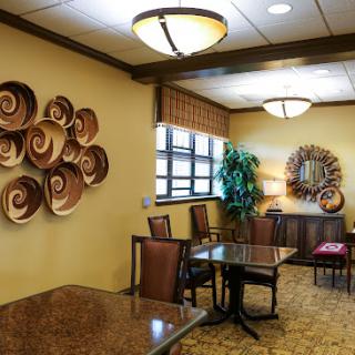 A cozy dining area featuring decorative wall art, warm lighting, and comfortable seating.