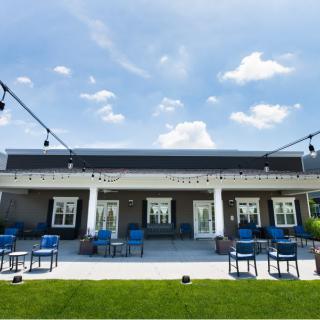 A modern outdoor patio with seating arrangements under a clear blue sky.