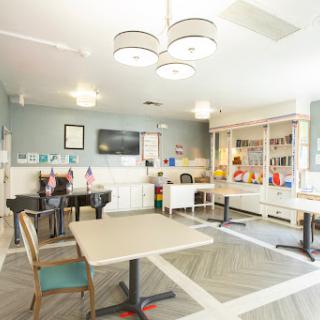 A bright and modern activity room featuring comfortable furniture and playful decor.