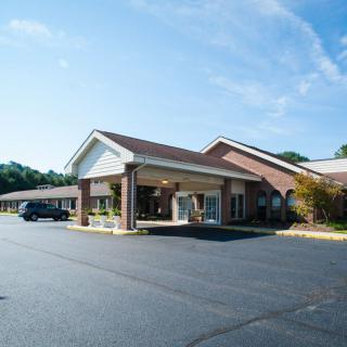 A single-story brick building with a covered entrance and adjacent parking lot.