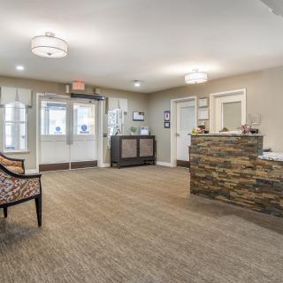 A modern reception area featuring a stone desk and comfortable seating.