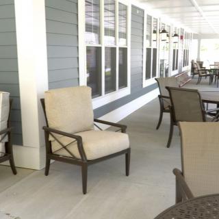 Outdoor patio area with comfortable seating and a row of windows.