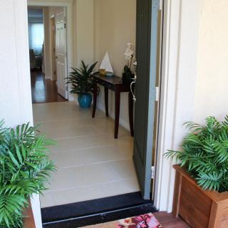 A welcoming entrance with decorative plants and an open front door.