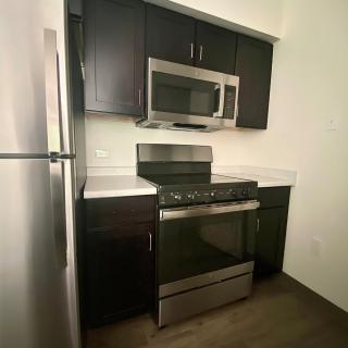 A modern kitchen with stainless steel appliances and dark wood cabinets.