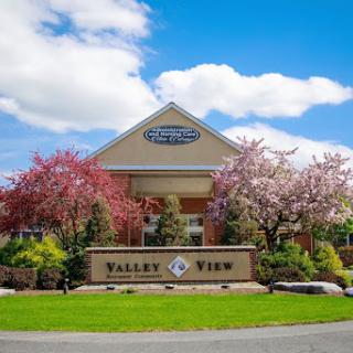 A vibrant spring day at Valley View, showcasing blooming flowers and a welcoming entrance.