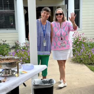 Two women enjoying a cheerful moment at an outdoor event.