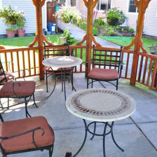A cozy gazebo with patio furniture set in a garden.