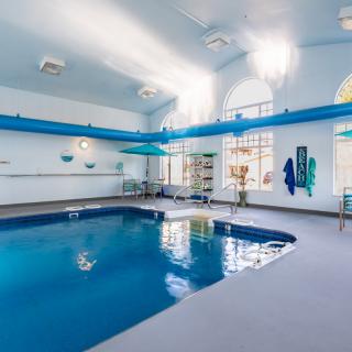 An indoor swimming pool with bright lighting and recreational amenities.