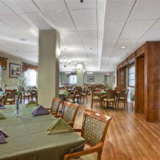 A spacious dining area with neatly arranged tables and chairs, featuring elegant place settings.