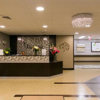 A modern reception area with a stylish desk and chandelier overhead.