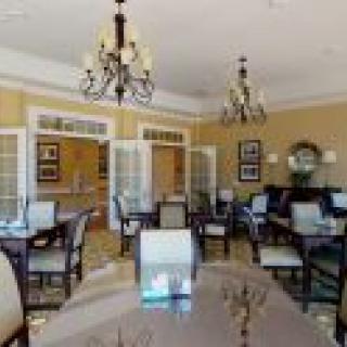 A well-decorated dining room with chandeliers and neatly arranged tables and chairs.