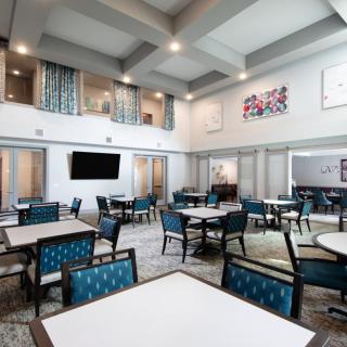 A modern and spacious dining area with neatly arranged tables and chairs.