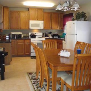A cozy kitchen with wooden cabinets and a dining area featuring a wooden table and chairs.
