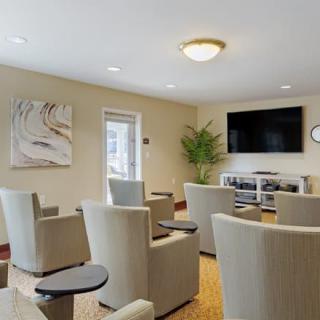 A modern seating area with comfortable chairs and a large television on the wall, suitable for meetings or relaxation.