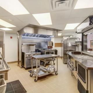 A clean and organized commercial kitchen equipped with stainless steel appliances and industrial cooking equipment.