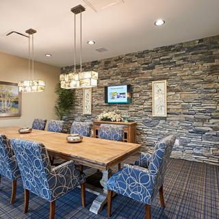 A modern dining room with a stone accent wall and stylish lighting fixtures.
