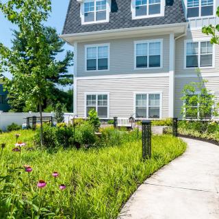 A residential building with a landscaped garden and a curved pathway.