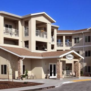 A modern apartment complex with multiple balconies under a clear blue sky.