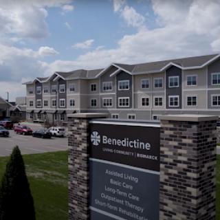 Exterior view of the Benedictine facility with a welcoming sign and residential apartments.
