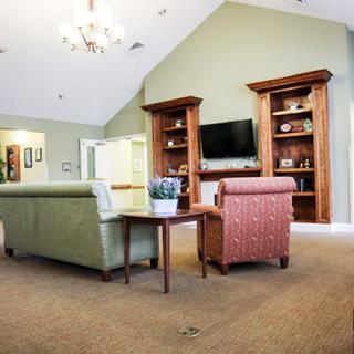 A cozy living room featuring comfortable seating, built-in bookshelves, and a television.