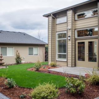 A modern house with a well-maintained lawn and patio area.