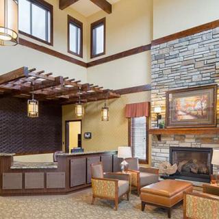 A modern lobby featuring a reception desk and cozy seating area with a fireplace.