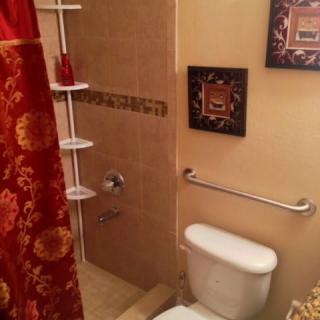 A cozy bathroom with a decorative shower curtain and artwork on the walls.