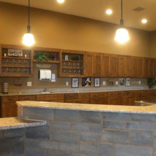 A modern kitchen with wooden cabinets and stone countertops under warm lighting.