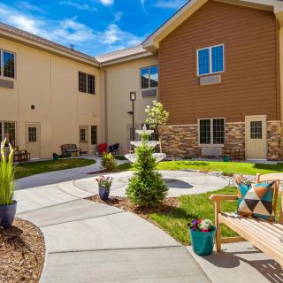 A serene courtyard with a fountain, surrounded by a landscaped garden and seating areas.