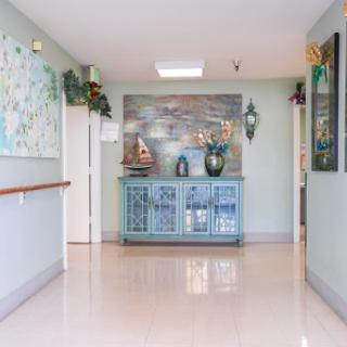 A well-decorated hallway featuring a reception area with decorative furniture and plants.