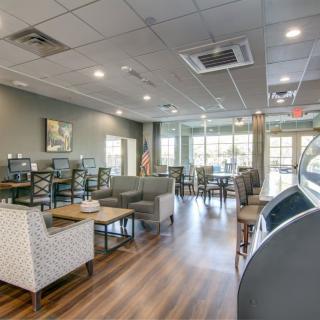 Modern cafe interior with comfortable seating and large windows.