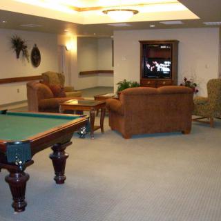 A cozy living room with a pool table and seating area.