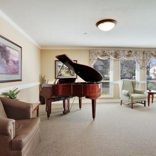 A cozy living room with a grand piano and comfortable seating.