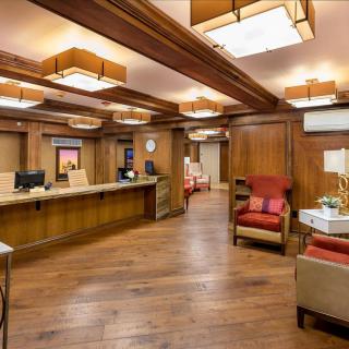 A warmly lit reception area with wooden interiors and comfortable seating.