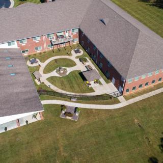 Aerial view of a building with a landscaped courtyard featuring pathways and green spaces.