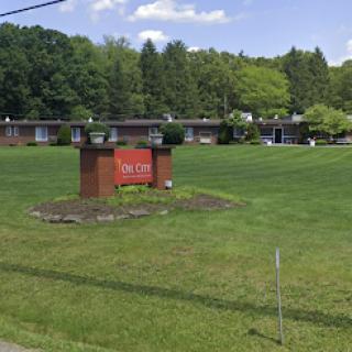 A view of a motel with a prominent sign, surrounded by lush green grass and trees.