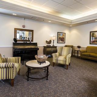 A cozy living room with striped chairs, a sofa, and decorative elements.