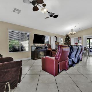 A spacious living room with recliners, a television, and modern decor.